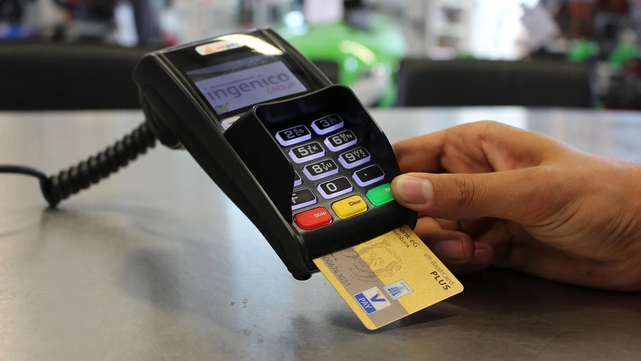 Cliente realiza pagamento por aproximação em uma maquininha.
