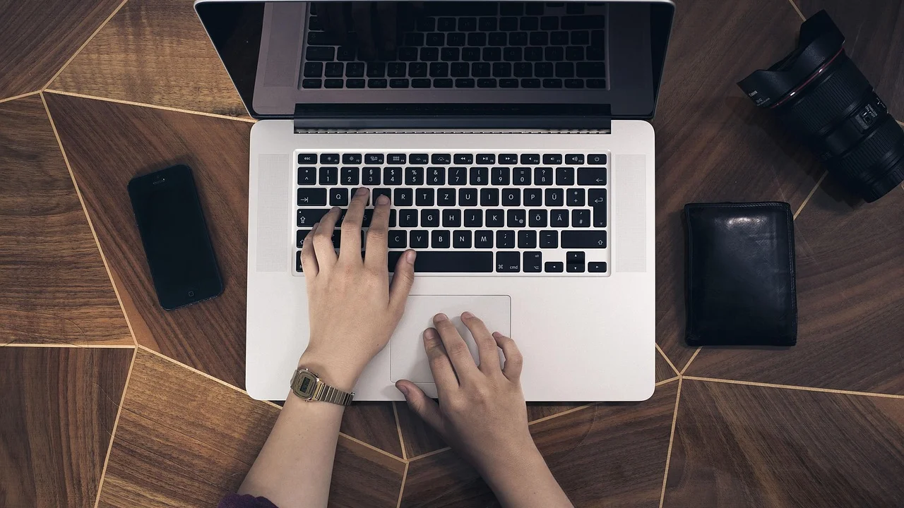 Notebook e celular conectados por Bluetooth sobre uma mesa de trabalho.