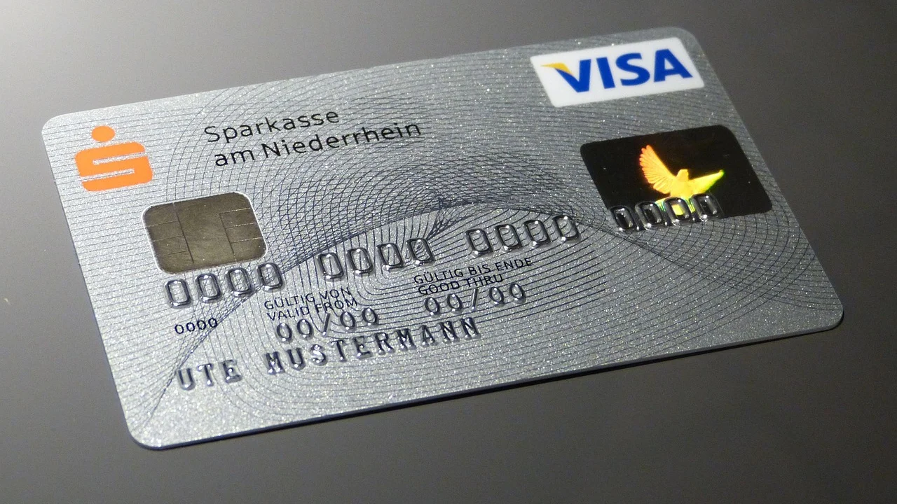 Cartão bancário e celular usados em uma consulta segura
