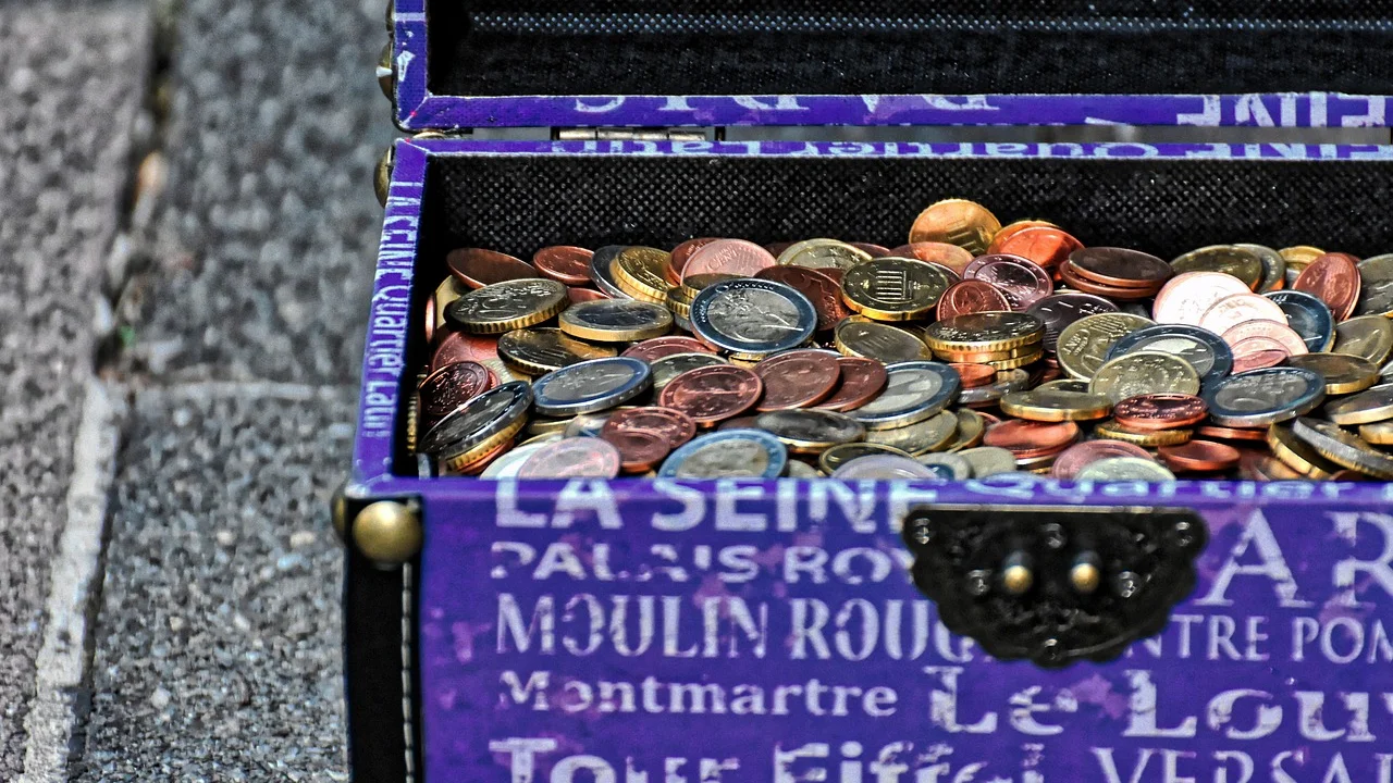 Calculadora ao lado de diferentes moedas usadas em viagens.