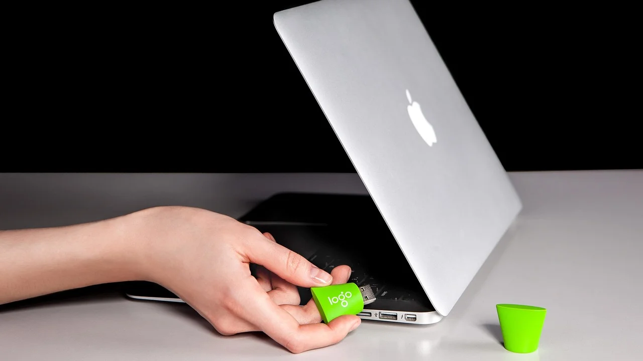 Pendrive de instalação ao lado de notebook e teclado