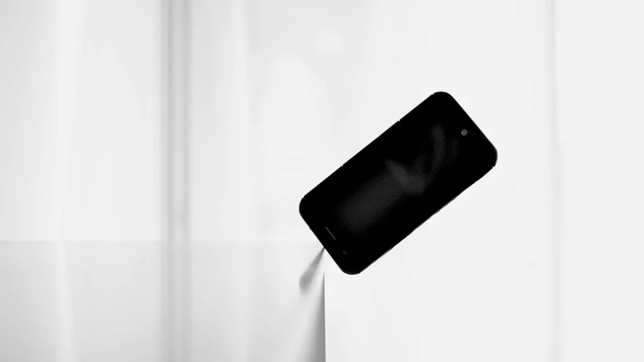 Livro e celular sobre uma mesa organizada