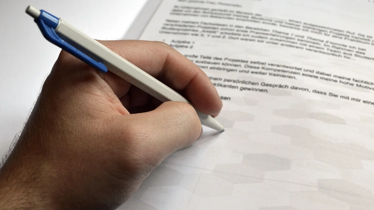 Pessoa escreve uma mensagem profissional em notebook.