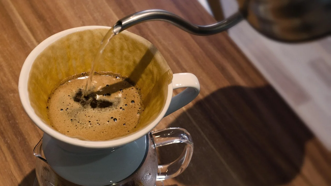 Xícara de café fresco ao lado de grãos torrados