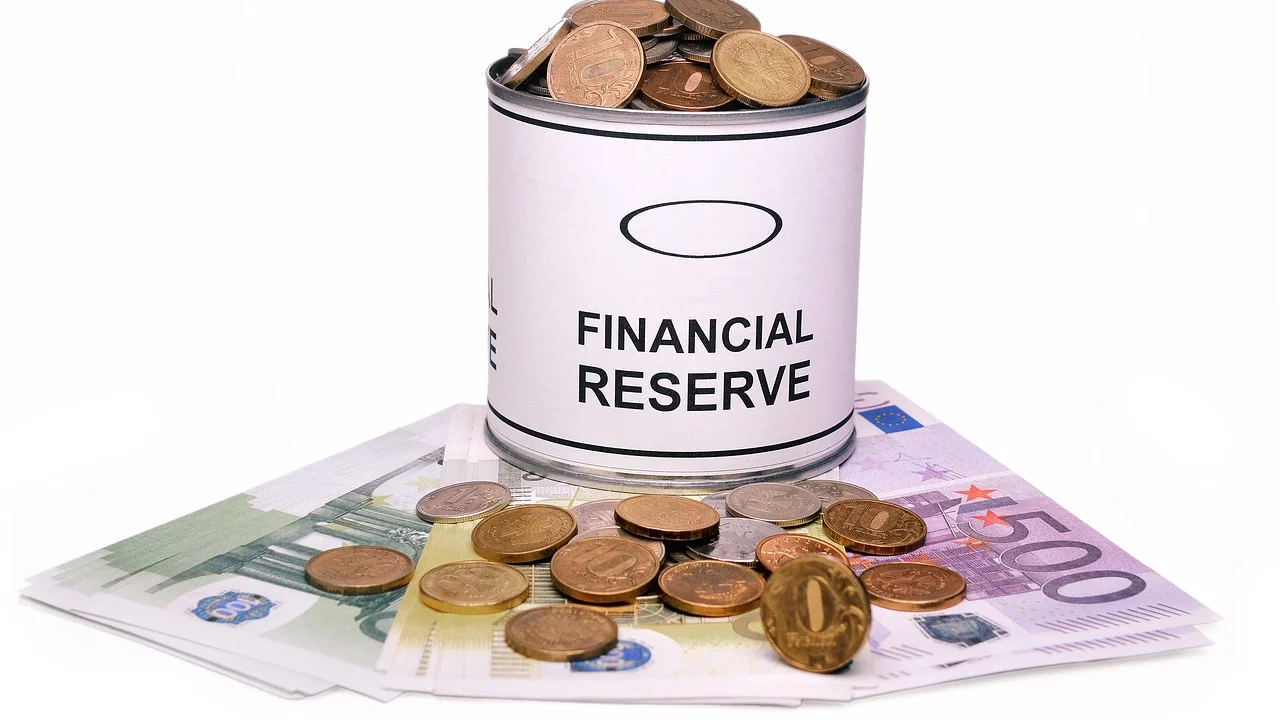 Pessoa organizando notas e moedas para uma reserva financeira.