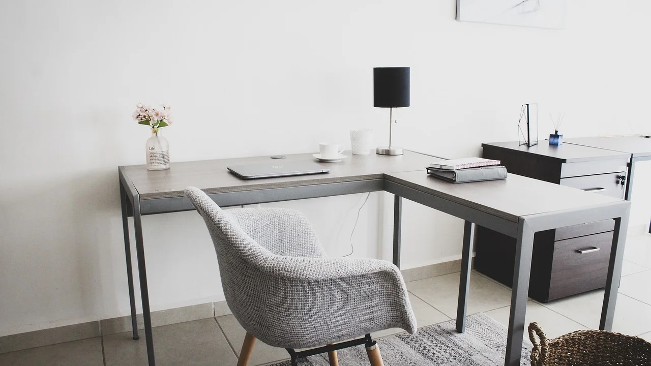Mesa de trabalho residencial organizada com computador e itens essenciais
