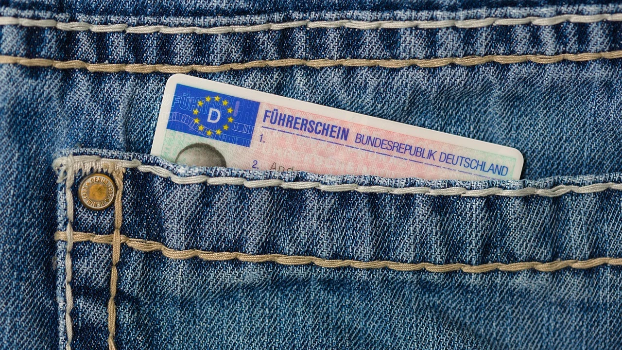 Carteira de motorista e documentos sobre uma mesa.