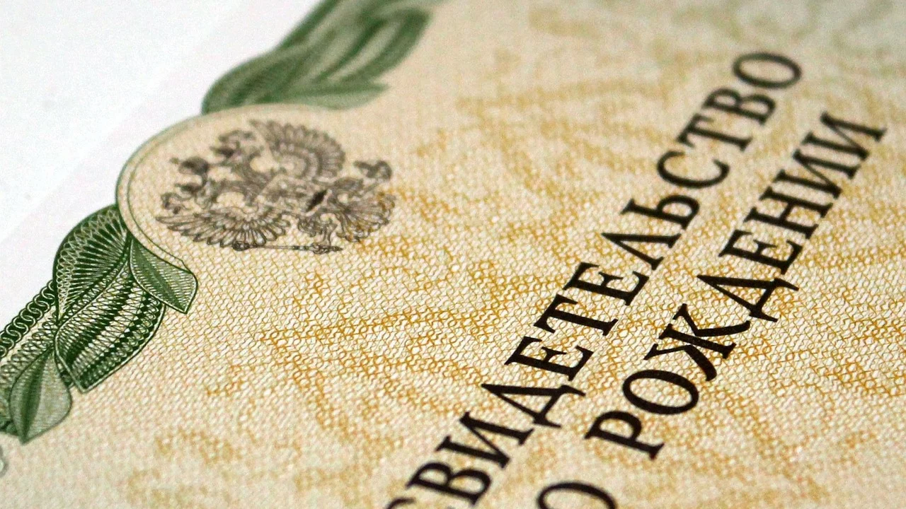 Certidão de nascimento aberta sobre uma mesa de atendimento