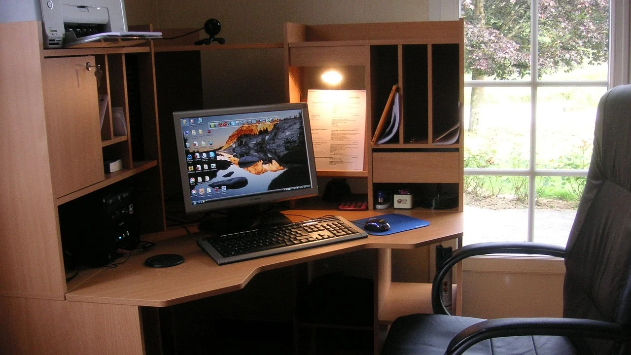 Impressora conectada a um notebook em ambiente de trabalho.