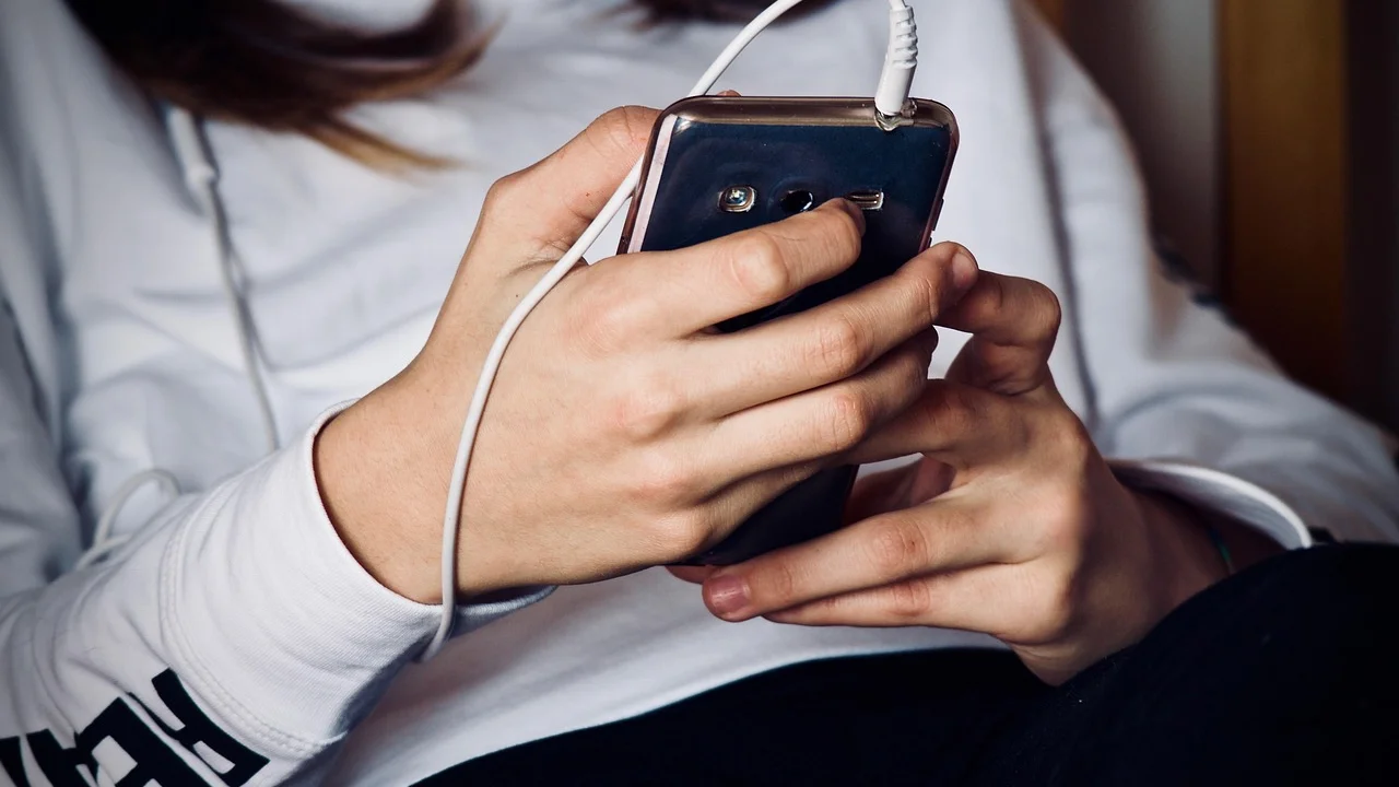 Fones e smartphone preparados para ouvir música durante uma viagem.