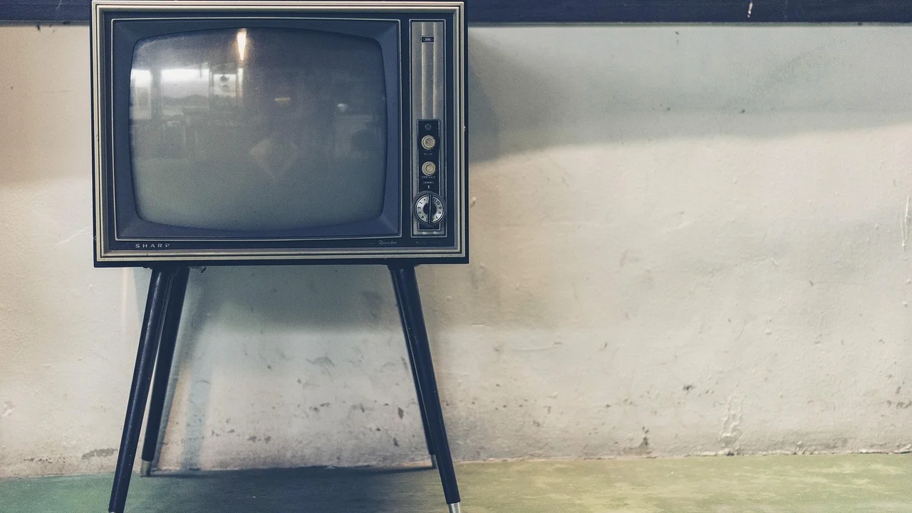 Controle remoto diante de uma smart TV com imagem colorida